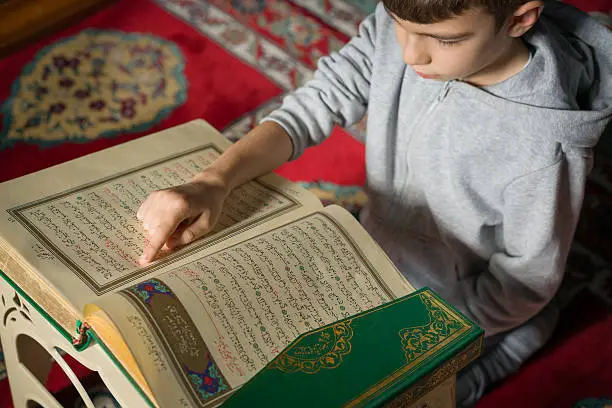 A young boy reading the Qur'an.
